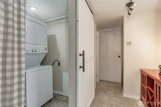 Utility room on the lower level with sliding barn door. There's space here for side-by-side washer/dryer if you prefer! Half bath and garage access to the right.