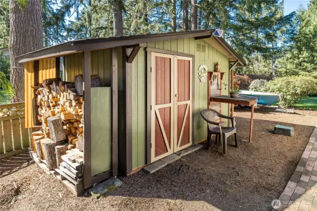 Charming garden shed with covered firewood storage