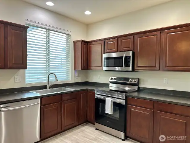 Dark accent cabinets add depth. You won't feel cramped in this kitchen!