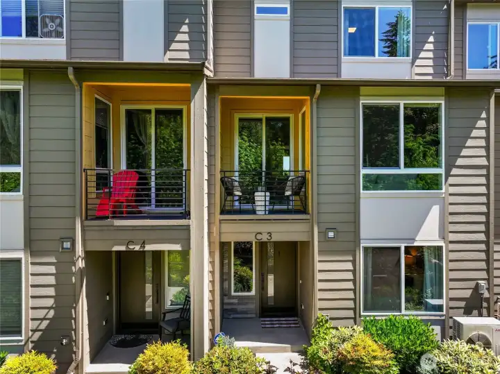 Covered balcony and front entry face the greenbelt.