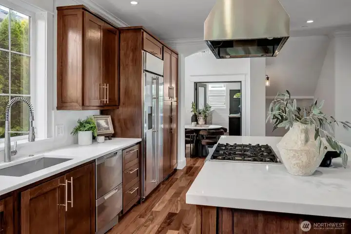 Designer Quartzite stuns in this gorgeous luxury kitchen with an abundance of features! State-of-the-Art appliances for the discerning host including Fisher & Paykel double ovens and dishwasher drawers, 6-burner range with dramatic stainless hood and large single basin sink with retractable brushed nickel faucet and modern hardware elevate this space.
