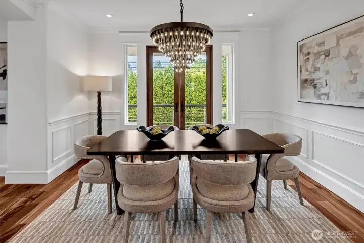 Striking detailing abound in this elegant dining room. Gorgeous lighting, wainscotting and French Door leading to a deck for BBQ's or just letting in the flowing breeze!