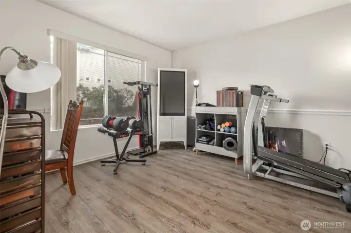 This exercise room with French doors could be a formal living room. Luxury vinyl plank floors.