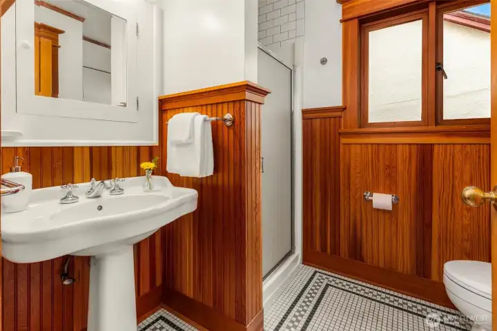 Main floor bathroom featuring custom tile and warm wood accents
