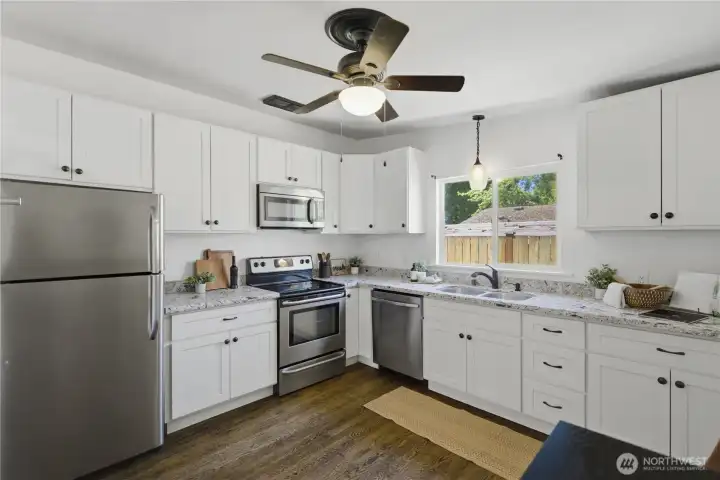 Open kitchen with granite countertops and a newer dishwasher
