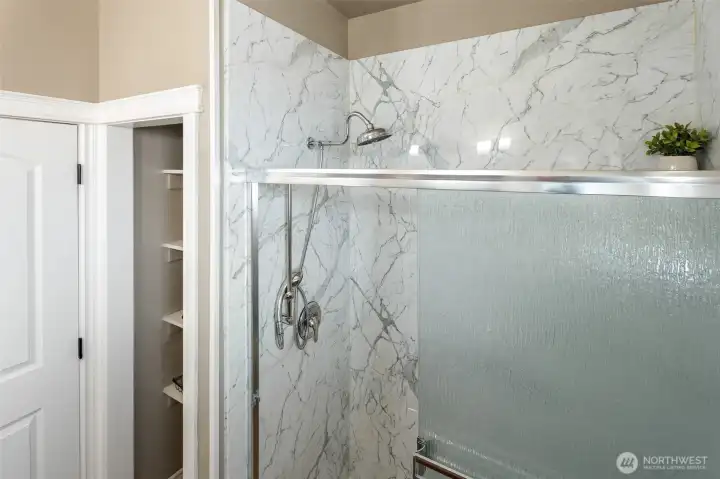 linen closet next to walk in shower