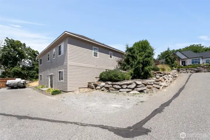 Side with additional parking pad- easy entrance to lower level. No backyard to mow!