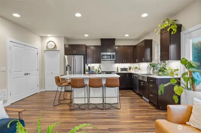 Functional and stylish kitchen with soft close cabinets, gorgeous white quartz counters, full height subway tile, and stainless farm sink.