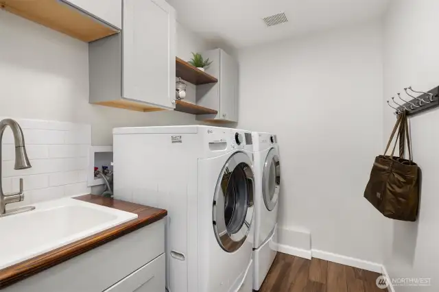 The remodeled and large laundry room w/new flooring, cabs and counters.
