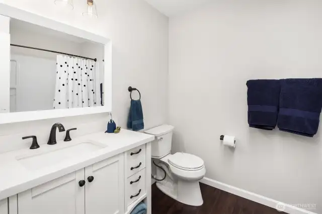 The guest, FULL and perfectly remodeled bathroom on the upper level of the home features new lighting,modern fixtures, flooring, vanity and tub surround and sunny skylight...too!