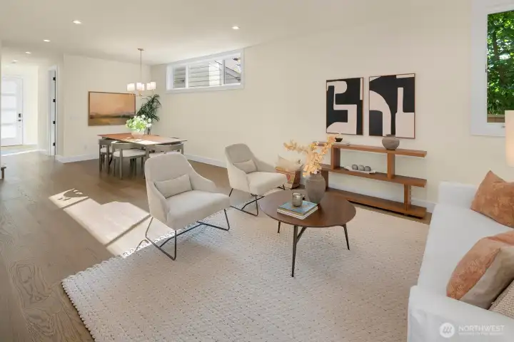 Open concept dining and living room area on the main floor. The main entrance has extra "mudroom" space and there's a powder room just behind the dining room area in this photo.