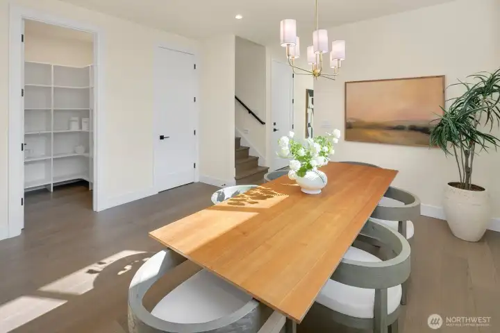 The open door on the left in this photo is a walk-in pantry and the closed door is a large storage closet that expands around and under the stairs. The third door is the entrance to the garage.