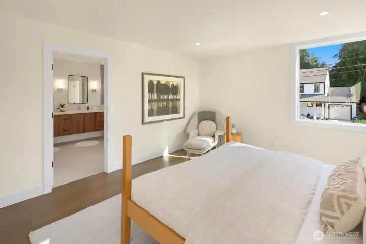 Primary bedroom has a large 3/4 bath with double vanity and frameless tiled shower.