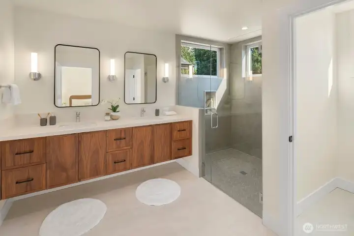 Lovely wood cabinetry and a frameless tiled shower.
