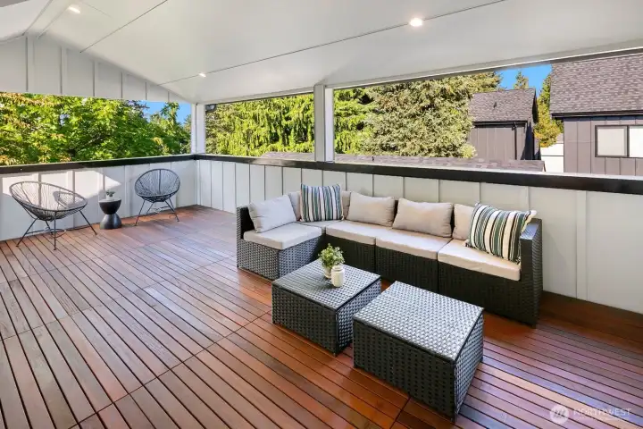The covered deck on the top level of the home has beautiful wood decking. The parapet wall creates privacy.