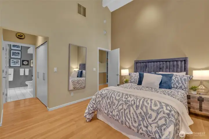 Another view of primary showing access to dual primary closets and four piece primary bath