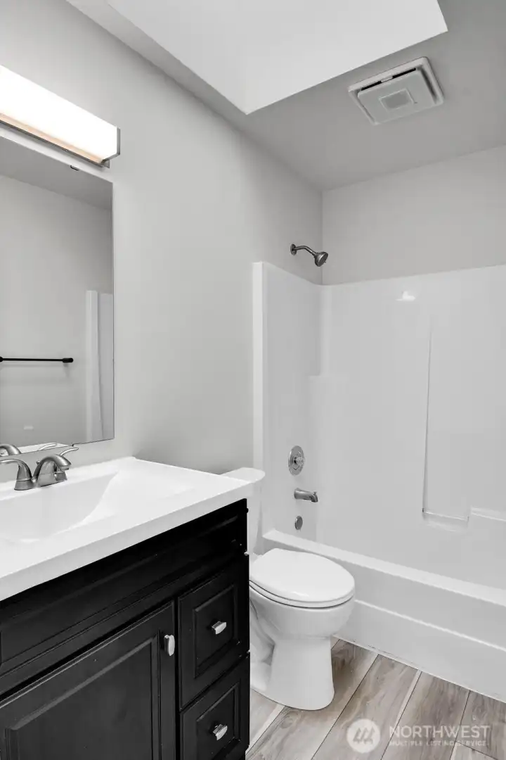 The ADU features a full bathroom with a skylight, providing ample natural light.