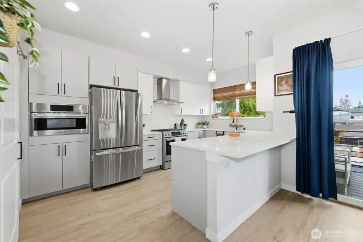 Thoughtfully designed kitchen with SS appliances, soft-close cabinetry, 3cm quartz countertops, a gas range, walk-in pantry, and abundant storage