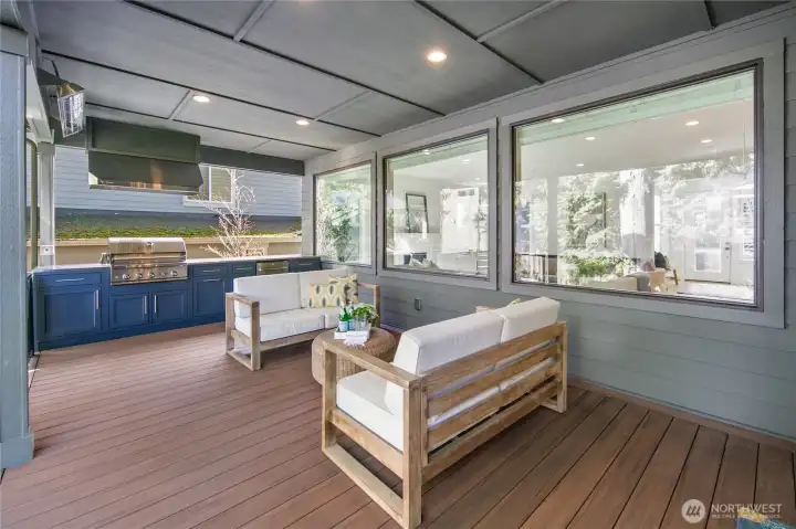Step outside to year-round Northwest living on the heated, covered deck featuring a built-in outdoor kitchen and covered dining space