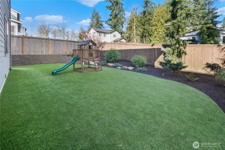 beautifully designed low-maintenance yard with turf play area