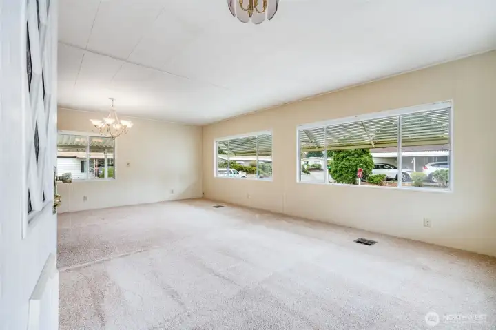 An enormous living room and connected dining area have huge windows providing tons of natural light!