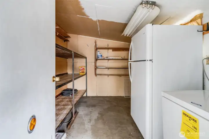 At the end of the carport is the large storage room with a refrigerator and chest freezer included with the home!