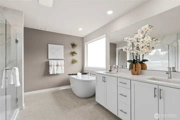 Primary suite offers dual sinks and soaking tub in addition to tiled shower