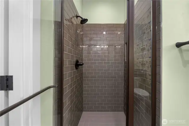 Fully tiled guest shower with upgraded (thicker) glass door.