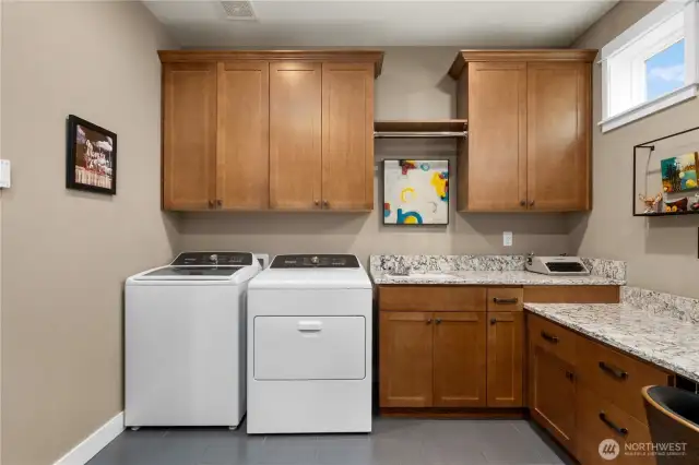Washer and dryer stay with the home, utility sink and tile floors.