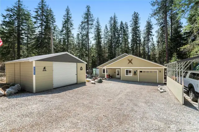 View of the enclosed carport that can fit 2 cars or several toys! Main house has attached one car garage with extra shop space!  Also included is additional carport for another car or more toys. Plenty of outside parking too!