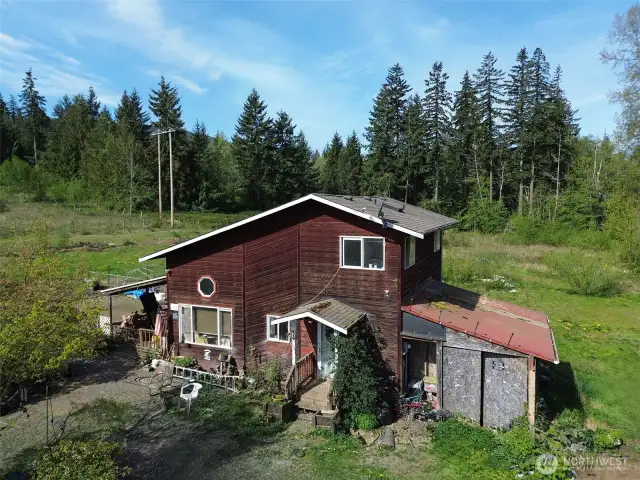 Country living yet ten minutes from town and the beach. Front of the house with land cleared around it.