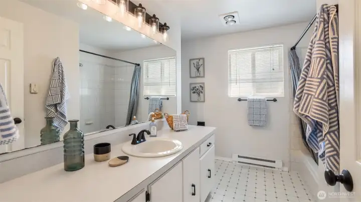 Bright guest bathroom with a full tub and shower combo.