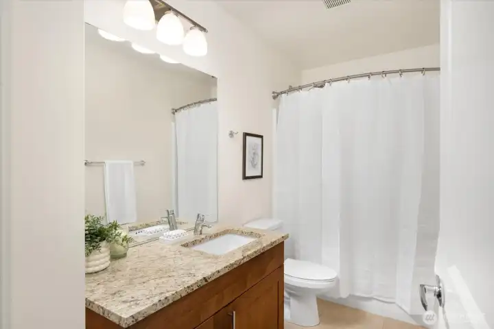 Guest bathroom with a beautiful vanity, and tiling.