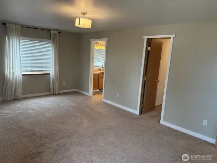 View of the Primary Suite showing doorways to the Ensuite Bath and Walk-in Closet.