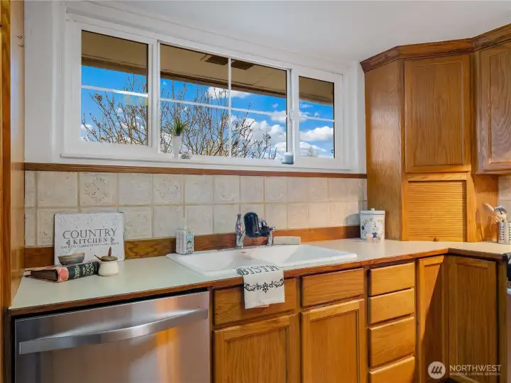 Do dishes with a view of the side yard. Appliance garage in this kitchen holds all those unsightly gadget while still being close by.