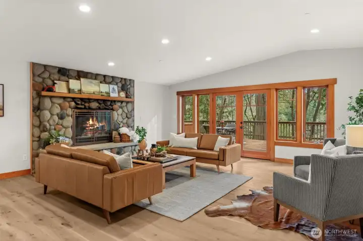 Living room with stone fireplace and connection to the outdoors