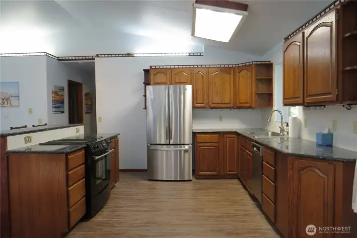 The kitchen is well appointed with shaker-style cabinets, granite countertops, island seating and appliances!