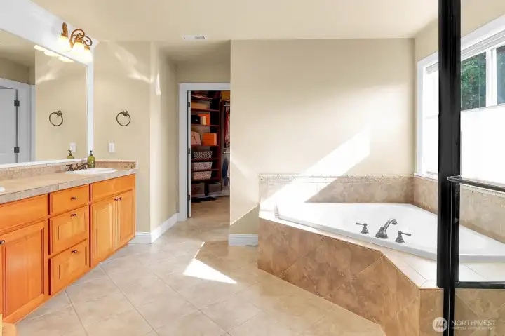 Primary 5 piece bathroom with angled soaking tub and shower