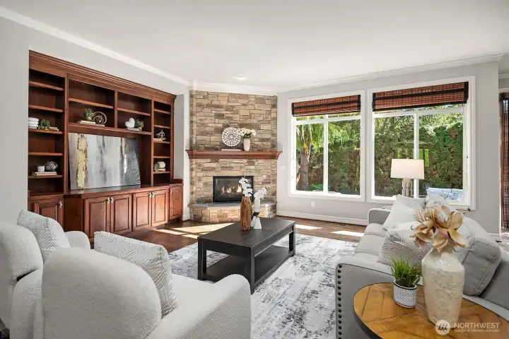 The spacious great room is a warm and inviting retreat, anchored by a classic fireplace with stone surround and flanked by rich built-in cabinetry and shelving. Large windows frame serene views of the private backyard, creating the perfect balance of comfort and elegance for everyday living and entertaining.
