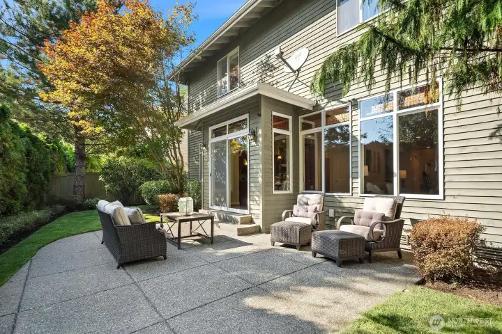 The expansive covered patio is an entertainer's dream, featuring a generous seating area surrounded by lush, mature landscaping that creates a sense of privacy and tranquility in this beautiful backyard retreat. This seamless indoor-outdoor connection perfectly extends the home's living space, offering an idyllic setting for al fresco dining, relaxing, and gathering with family and friends year-round.