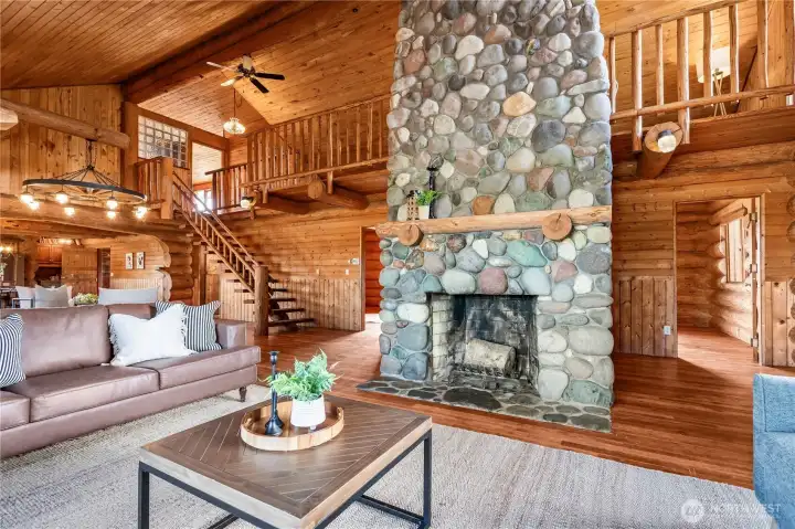 The towering river rock fireplace is the centerpiece of this space