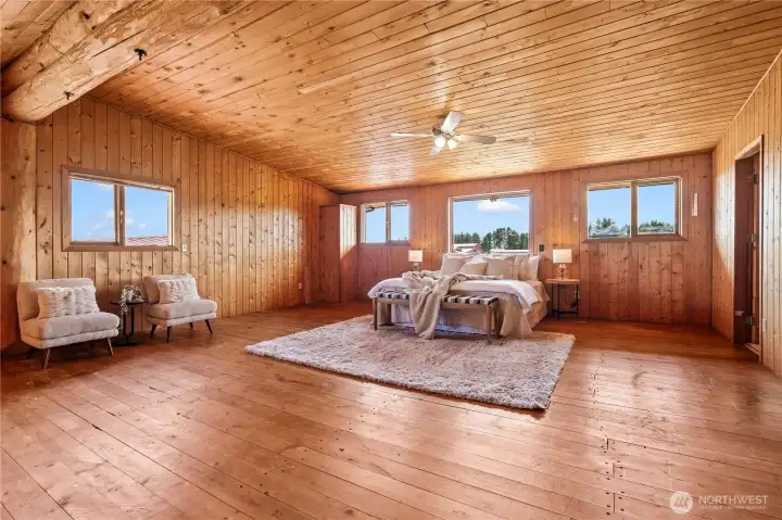 Upstairs, the massive primary bedroom has ample space for a sitting area/reading nook and more