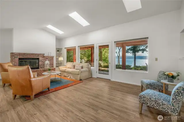 Enjoy views year round in spacious living room with vaulted ceilings, skylights and wood burning fireplace. New flooring and paint.