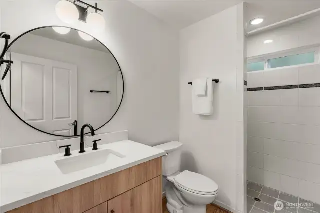 New European bath vanity and quartz counter. New faucet, mirror and light fixture. New toilet and new towel hardware.