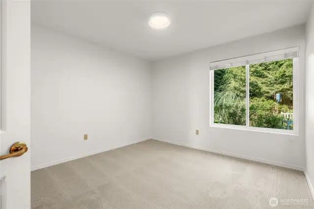 Bedroom 2 with new carpet, paint and updated light fixture.