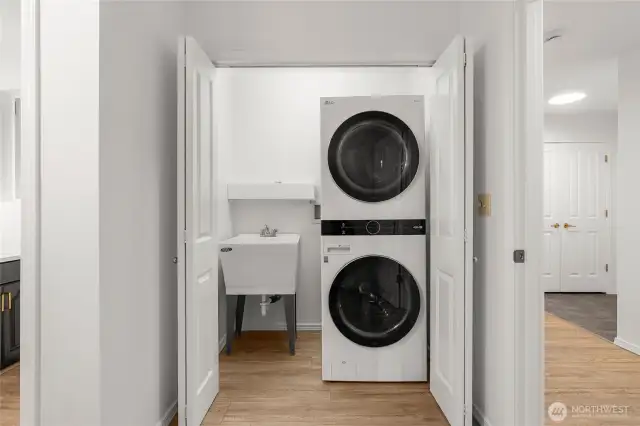 Laundry/Utility room boasts newer stacking W/D, laundry sink and tons of storage - and bonus half bath.