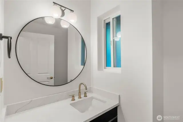 Updated half bath in utility room with brand new quartz counter/sink/faucet/mirror and light fixture. New toilet as well.