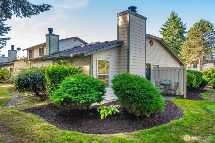 Beautifully maintained building with lush landscaping and mature trees