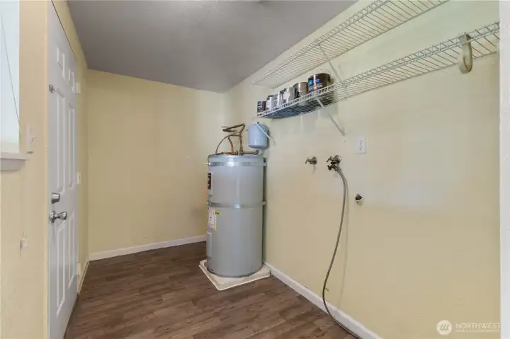 Utility room with washer/dryer and additional storage space.