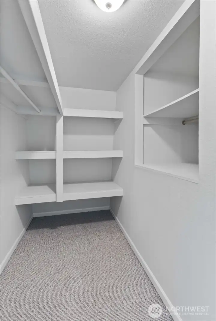 Walk-in closet with shelving for all your storage needs.